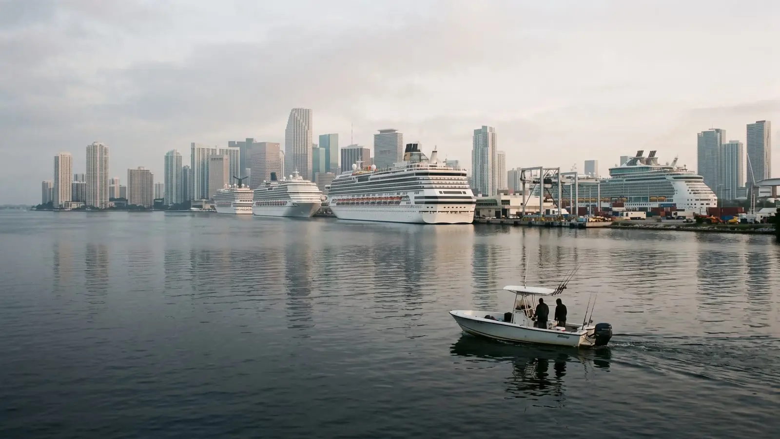 Cruceros atracados en PortMiami vistos desde Biscayne Bay, con un bote pequeño al frente