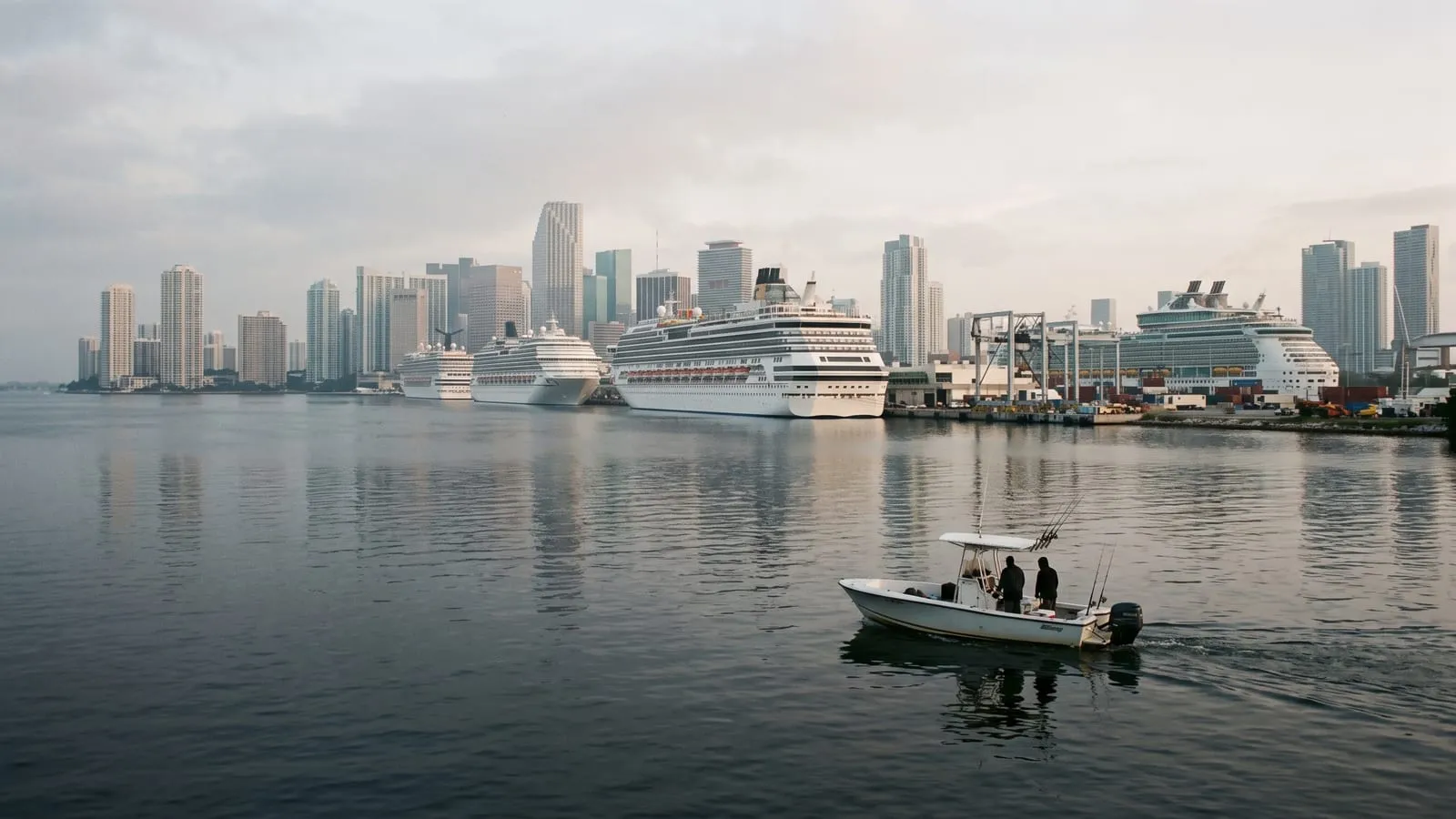 Cruise ships docked at PortMiami seen across Biscayne Bay, a small boat in the foreground